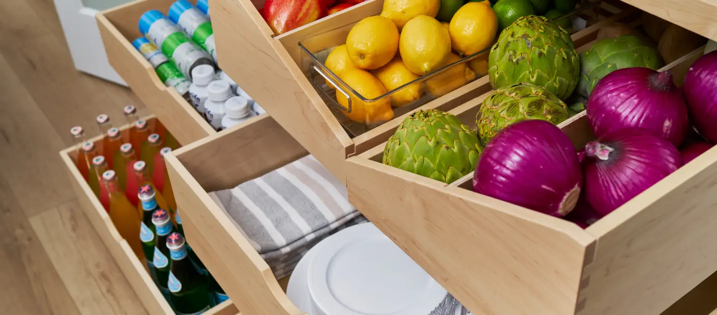 Cabinet drawers open with fruit and vegetables.
