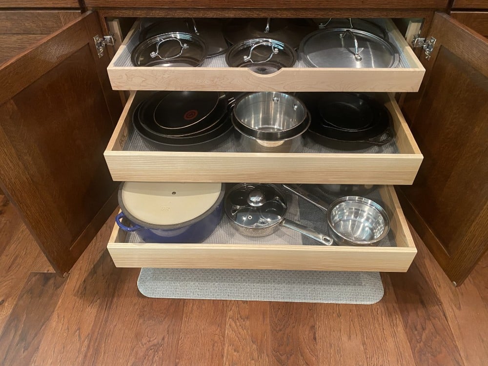 This kitchen already had glide-outs. We moved their existing middle glide out and added a third one to make a home for their pan lids.