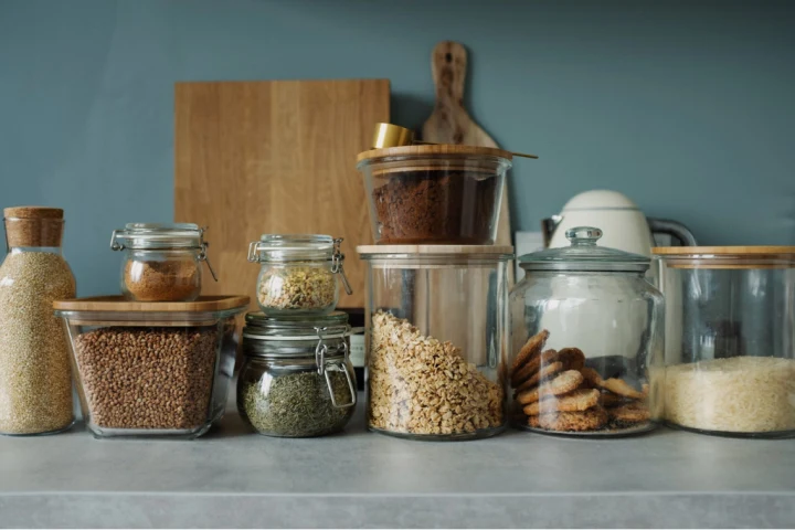 A group of glass jars with food on a counter.