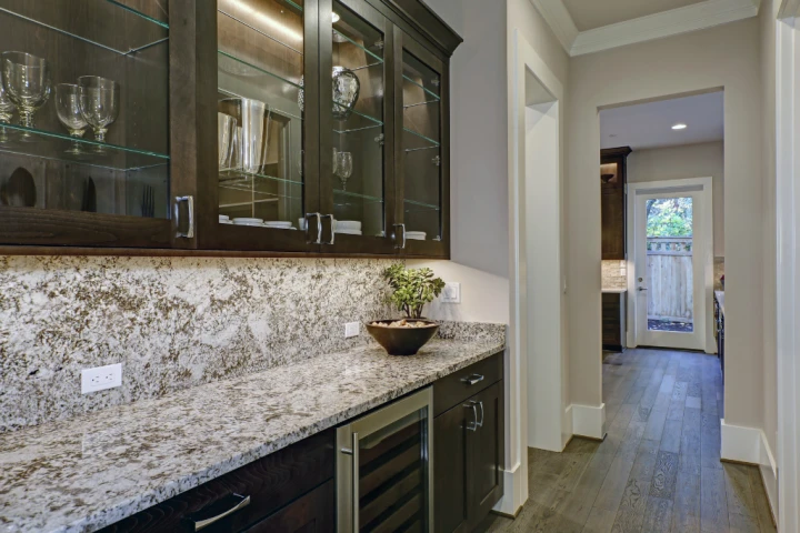 A kitchen with glass cabinets and a potted plant.