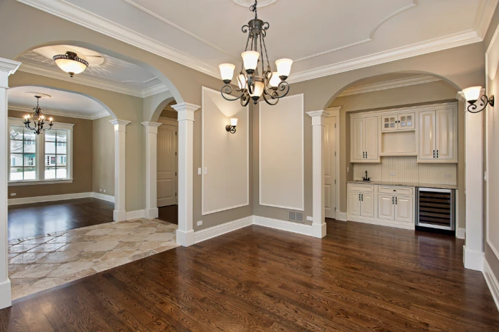 a room with a chandelier and hardwood floor.