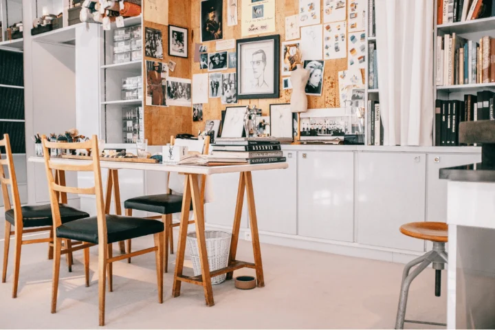 A room with a pictures and bookshelves.