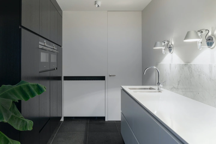 Minimalist kitchen with multiple cabinets and shelving units.
