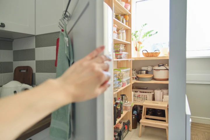 A hand reaching out to a kitchen.