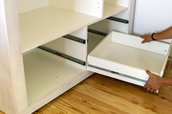 Close up of wooden drawer box and front being installed in contemporary cabinet.